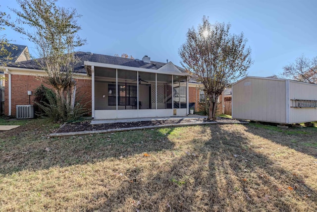 back of property with a sunroom, central AC unit, and a lawn