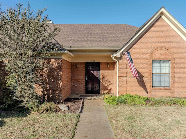 property entrance featuring a lawn