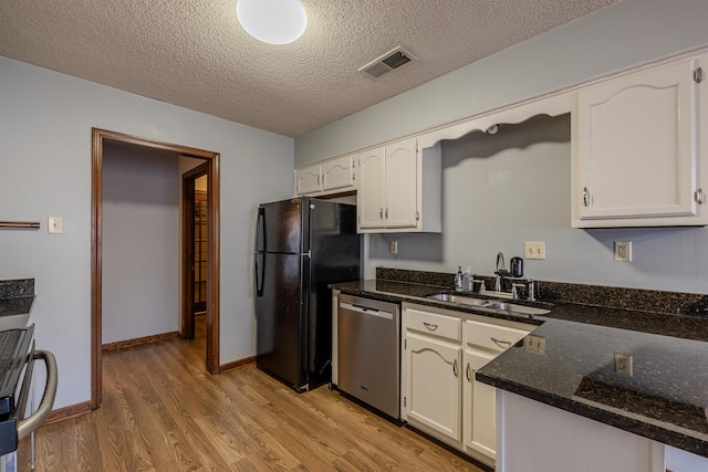 kitchen featuring white cabinetry, sink, light hardwood / wood-style floors, a textured ceiling, and appliances with stainless steel finishes