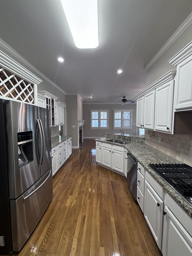 kitchen featuring white cabinetry, sink, dark wood-type flooring, stainless steel appliances, and kitchen peninsula