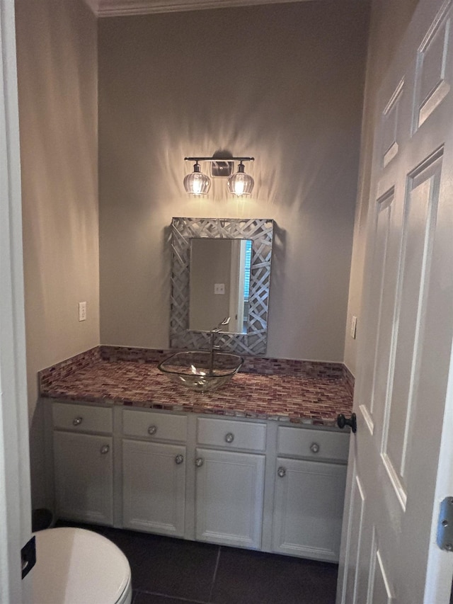 bathroom with tile patterned floors, vanity, toilet, and crown molding