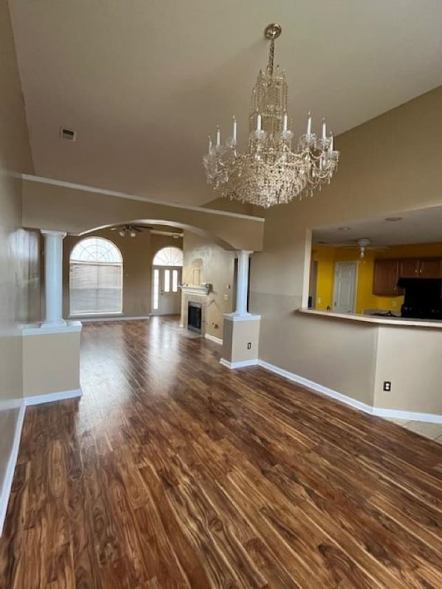 unfurnished living room featuring a chandelier, vaulted ceiling, and hardwood / wood-style flooring