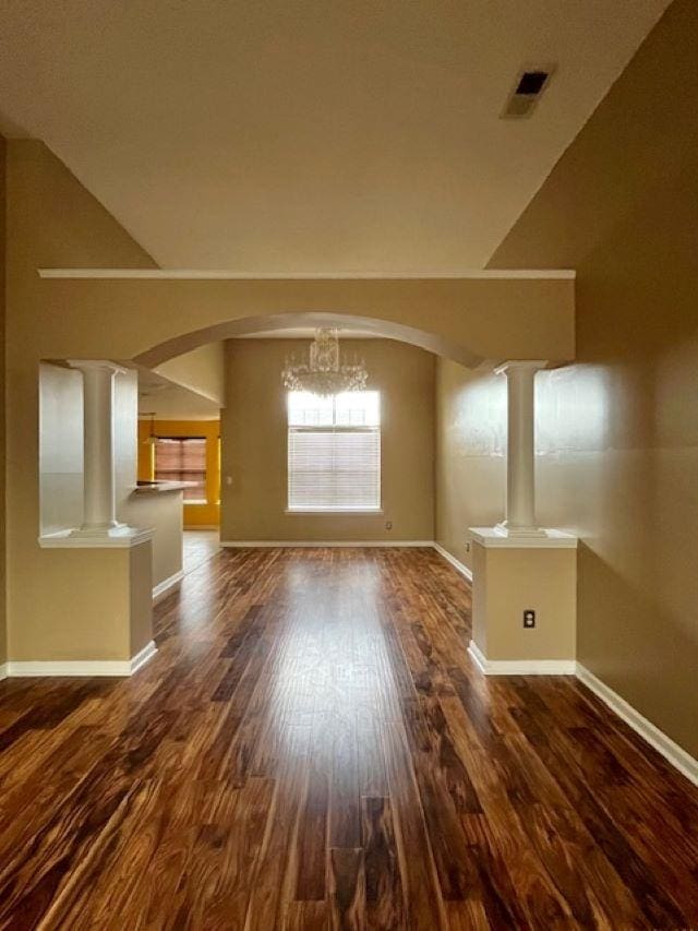 interior space with dark hardwood / wood-style flooring, lofted ceiling, and an inviting chandelier