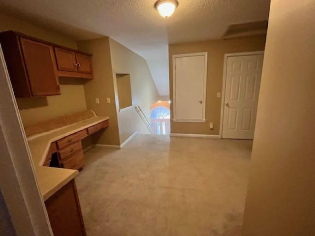 interior space with lofted ceiling, a textured ceiling, and light carpet