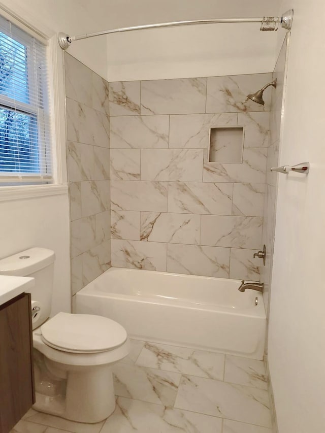 full bathroom featuring tiled shower / bath, vanity, and toilet