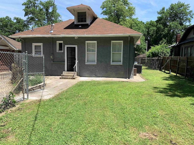 back of house with a yard and central AC unit