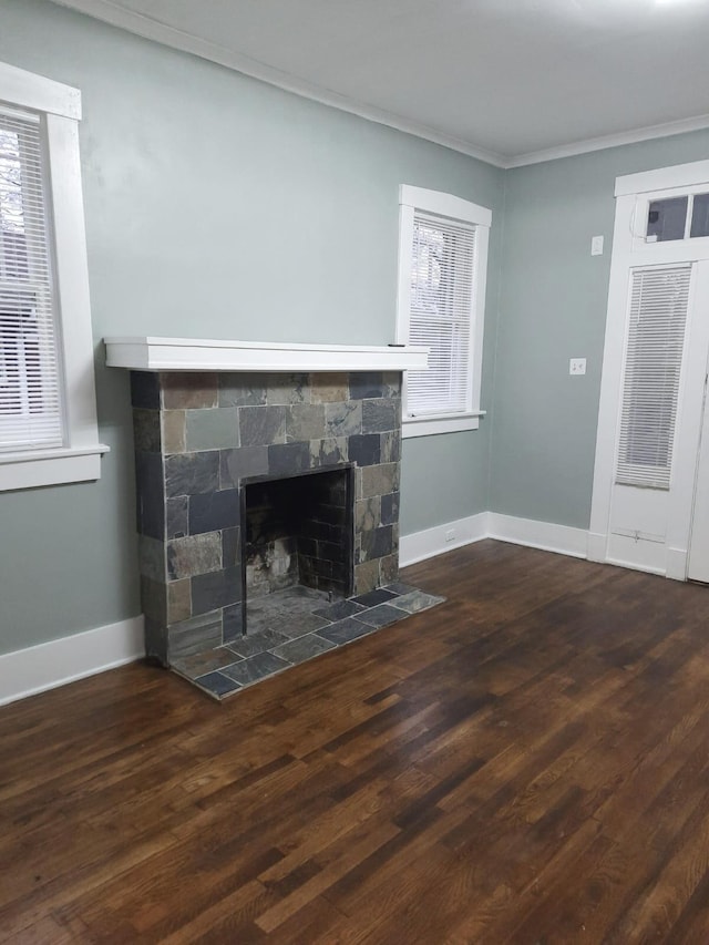 unfurnished living room featuring crown molding, a fireplace, dark wood-type flooring, and plenty of natural light