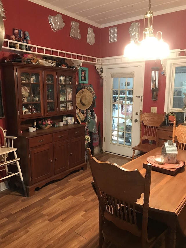 dining space with an inviting chandelier, light hardwood / wood-style flooring, and crown molding