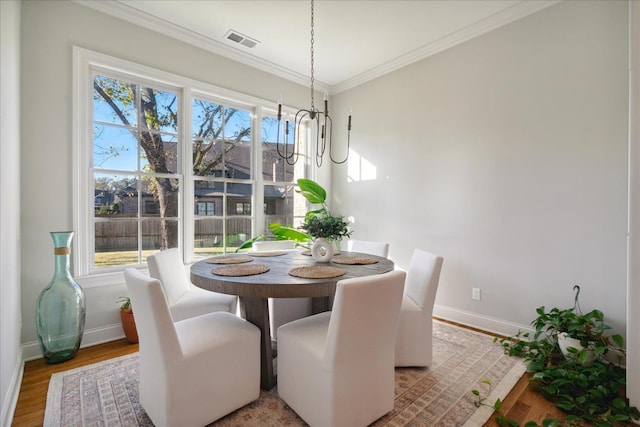 dining room with hardwood / wood-style flooring and ornamental molding