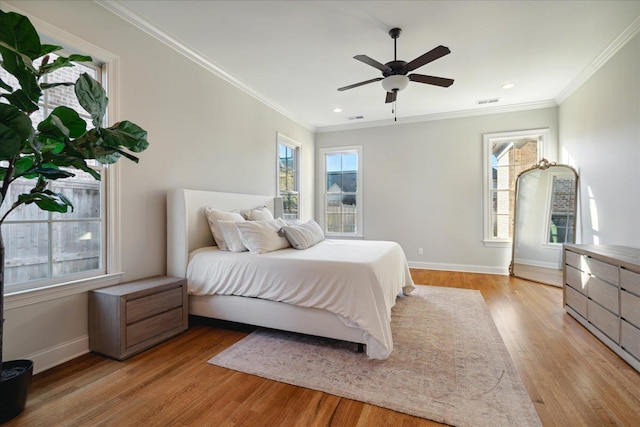 bedroom featuring ceiling fan, light wood-type flooring, and crown molding