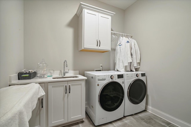 washroom with cabinets, independent washer and dryer, light hardwood / wood-style flooring, and sink