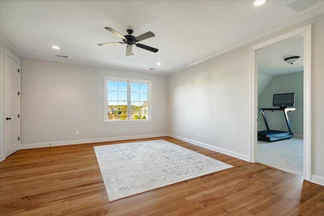 empty room featuring ceiling fan, crown molding, and hardwood / wood-style flooring