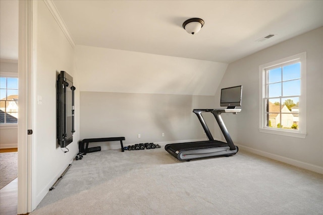 workout room featuring crown molding, light colored carpet, and vaulted ceiling