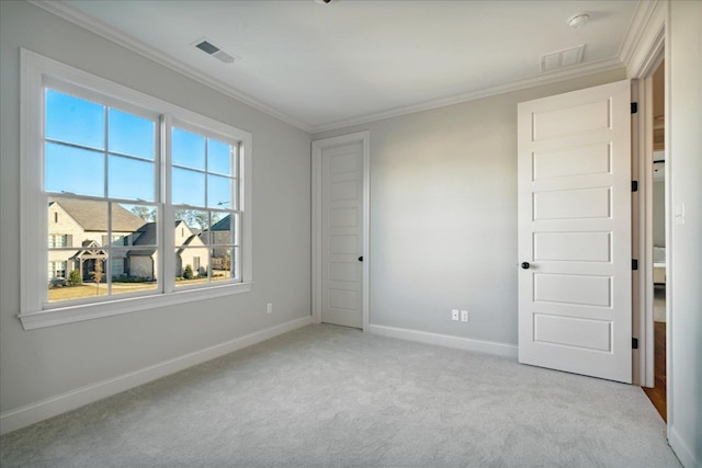 unfurnished bedroom featuring light colored carpet, crown molding, and multiple windows