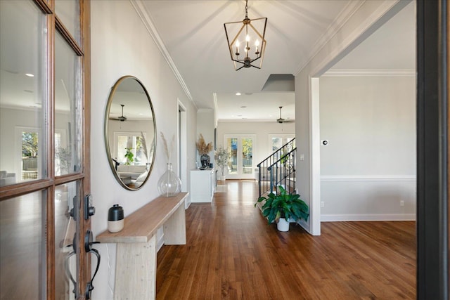 foyer entrance with ceiling fan with notable chandelier, dark wood-type flooring, and a healthy amount of sunlight