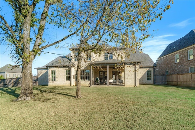 rear view of house featuring a patio area and a yard