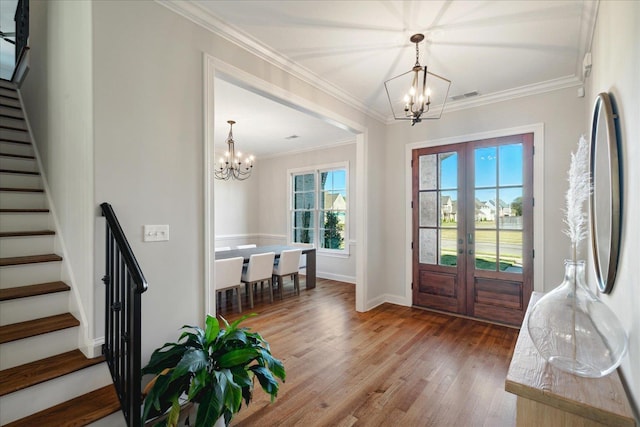 entryway with crown molding, french doors, a chandelier, and hardwood / wood-style flooring