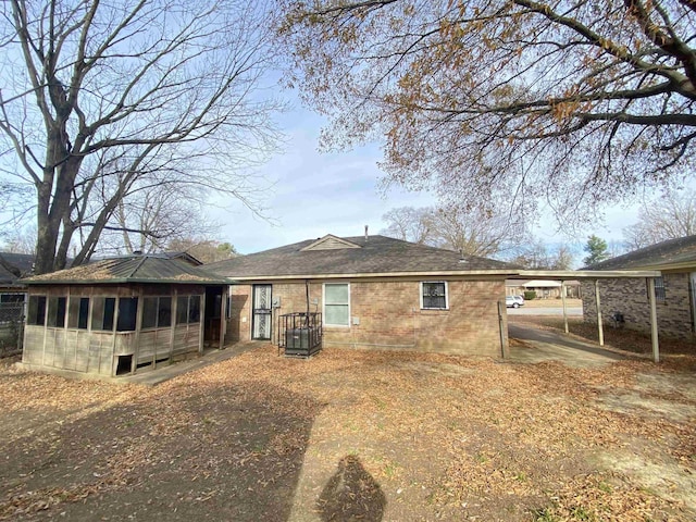 back of property featuring a sunroom and a carport