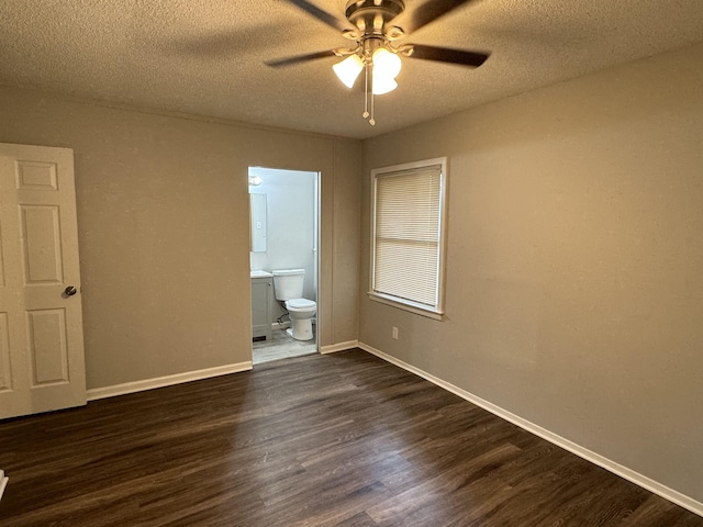 unfurnished bedroom featuring a textured ceiling, ensuite bathroom, ceiling fan, and dark wood-type flooring