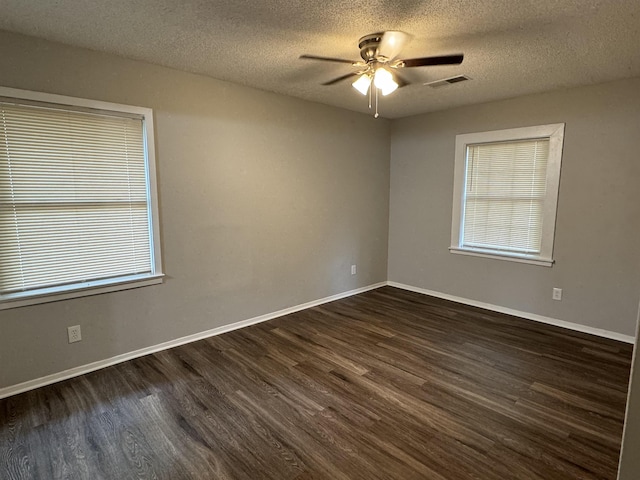 empty room with ceiling fan, dark hardwood / wood-style flooring, and a textured ceiling