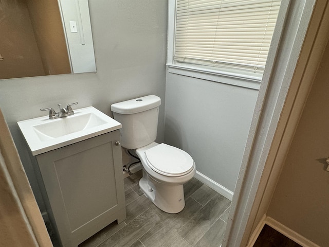 bathroom with wood-type flooring, vanity, and toilet