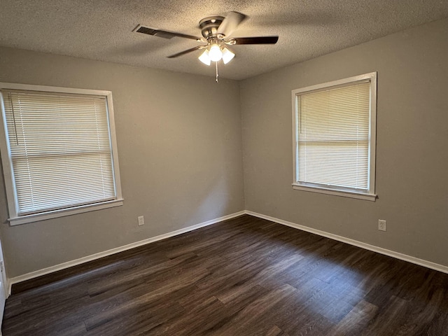 empty room featuring ceiling fan, dark hardwood / wood-style flooring, and a textured ceiling