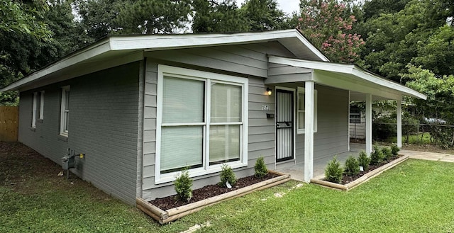 view of side of home with a yard and a porch