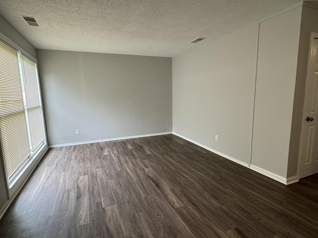 unfurnished room featuring a textured ceiling and dark wood-type flooring