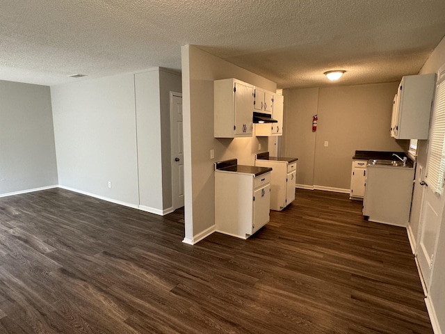 kitchen featuring white cabinets, a textured ceiling, dark hardwood / wood-style floors, and sink