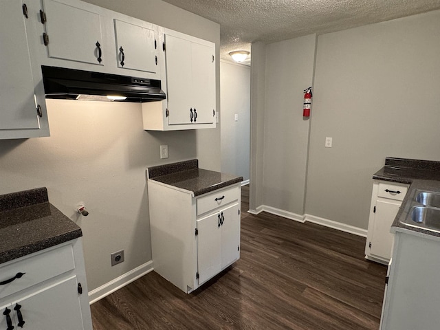 kitchen with a textured ceiling, white cabinetry, and dark wood-type flooring