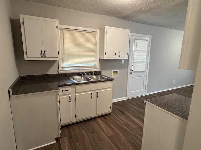 kitchen featuring white cabinets, dark hardwood / wood-style flooring, sink, and a textured ceiling