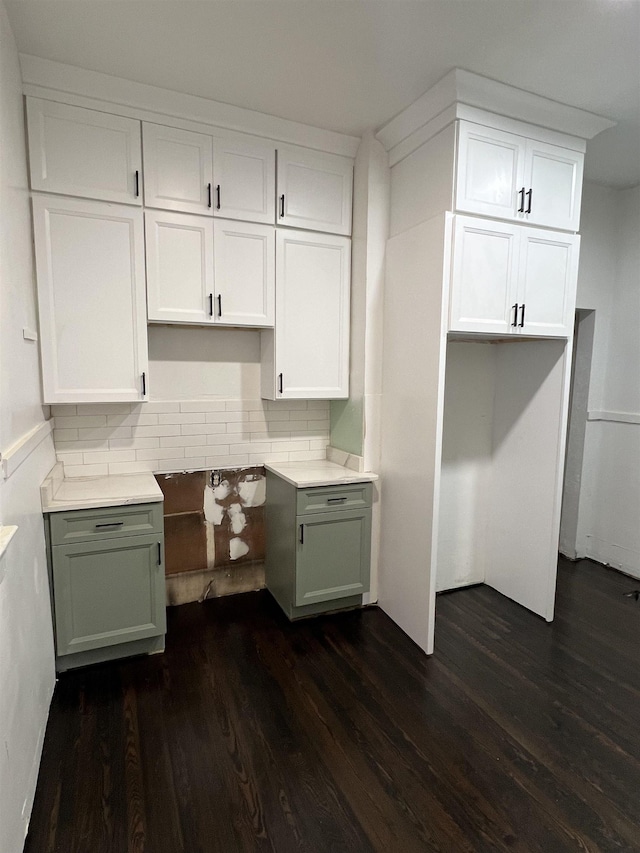 kitchen with dark hardwood / wood-style floors, white cabinetry, and backsplash