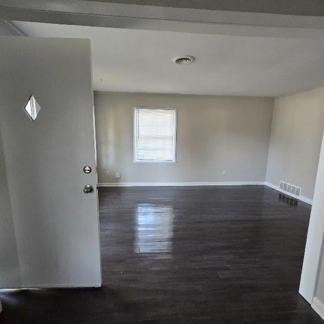 spare room featuring dark wood-type flooring