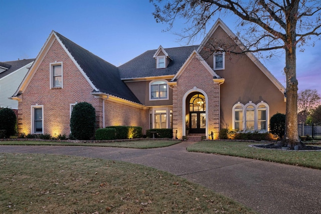 front facade with french doors and a lawn