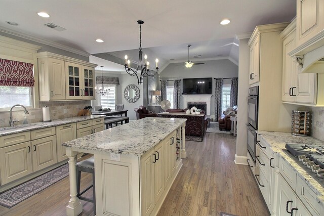 kitchen featuring wood-type flooring, ceiling fan with notable chandelier, plenty of natural light, and sink