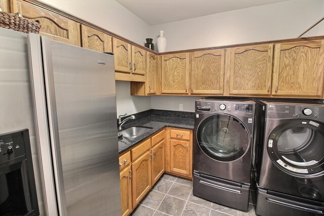 washroom with separate washer and dryer, sink, and tile patterned flooring