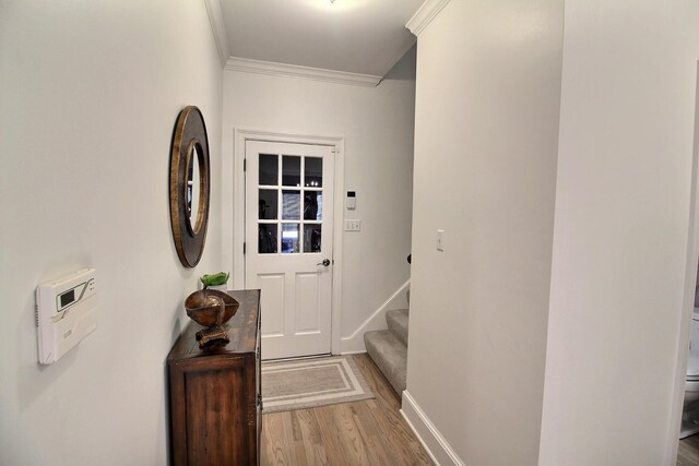 doorway to outside featuring light hardwood / wood-style flooring and ornamental molding