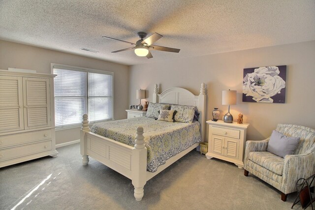 bedroom featuring ceiling fan, carpet, and a textured ceiling