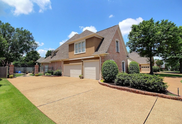 595 Kenrose St, Collierville, TN 38017 - view of front of home with an attached garage, driveway, brick siding, a shingled roof, and stucco siding