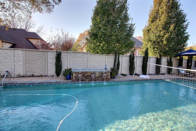 view of swimming pool with exterior bar