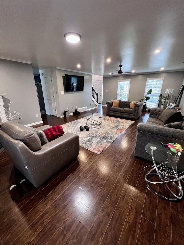 living room with dark hardwood / wood-style flooring, ceiling fan, and crown molding