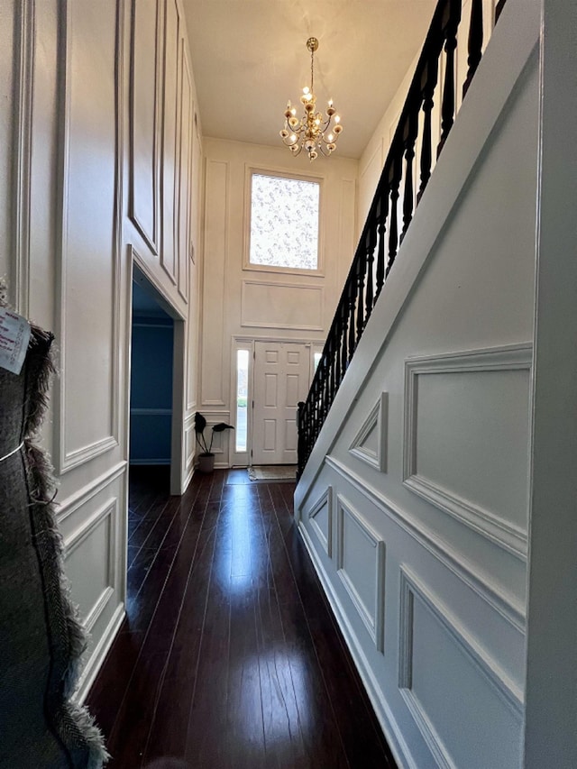 foyer entrance featuring dark hardwood / wood-style flooring and a chandelier