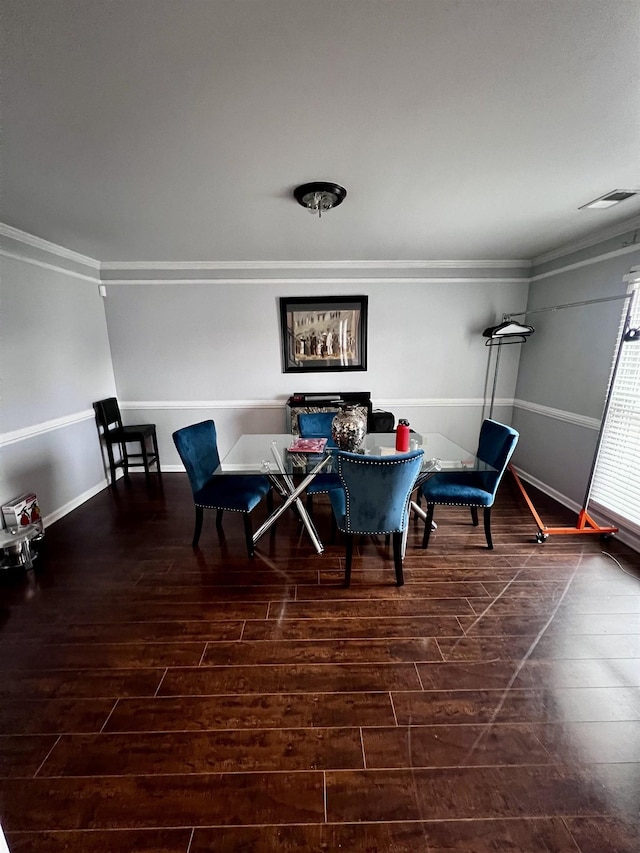 dining space with dark hardwood / wood-style flooring and crown molding