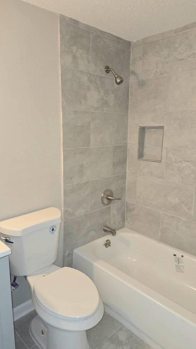 full bathroom featuring vanity, a textured ceiling, toilet, and tiled shower / bath