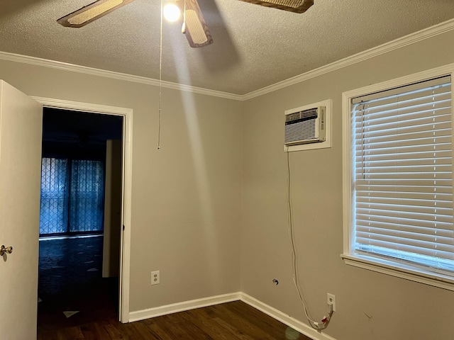 unfurnished room featuring dark hardwood / wood-style flooring, a textured ceiling, a wall mounted AC, and ornamental molding