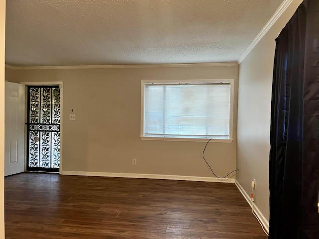 spare room featuring crown molding, dark wood-type flooring, and a textured ceiling