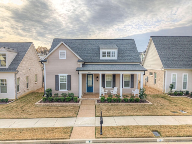 view of front facade featuring covered porch and a front lawn