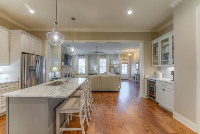 kitchen with white cabinets, sink, stainless steel refrigerator with ice dispenser, and wine cooler