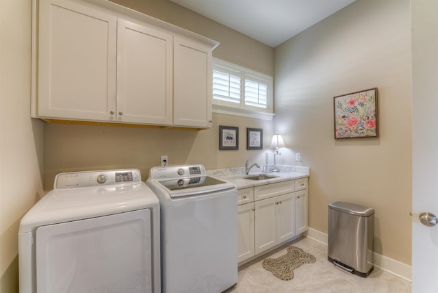 laundry area with cabinets, washer and clothes dryer, and sink