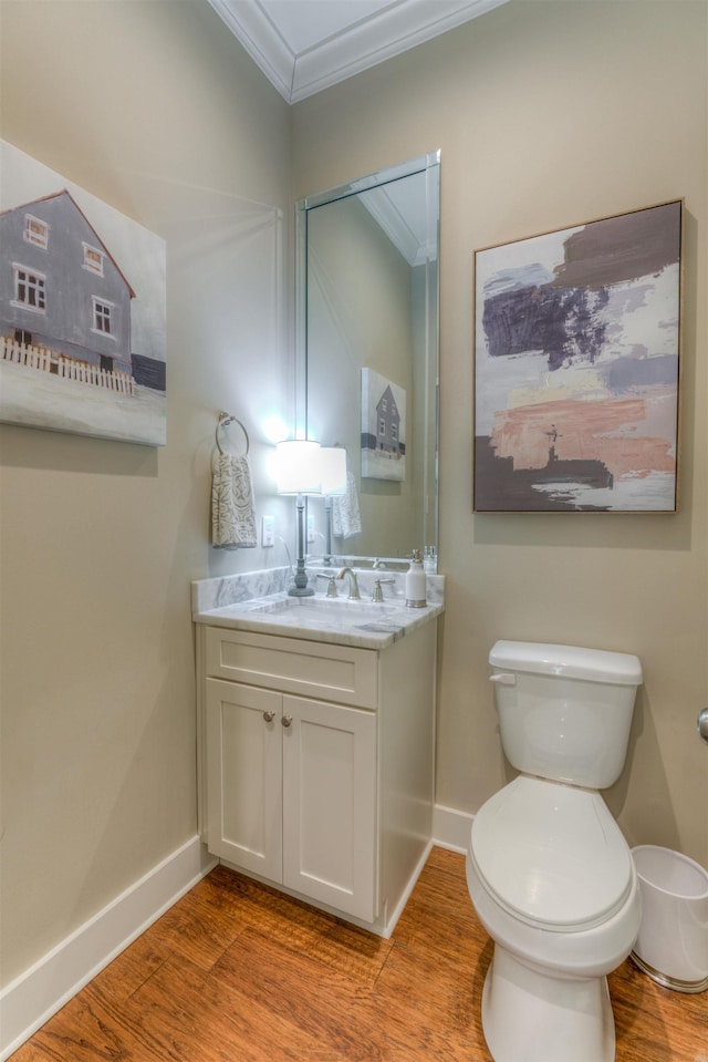 bathroom featuring hardwood / wood-style floors, vanity, toilet, and ornamental molding